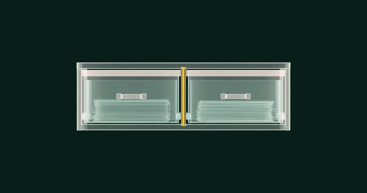 Cassettiera a due cassetti affiancati, ciascuno con un plico di fogli: dorato è il divisorio che li separa.
